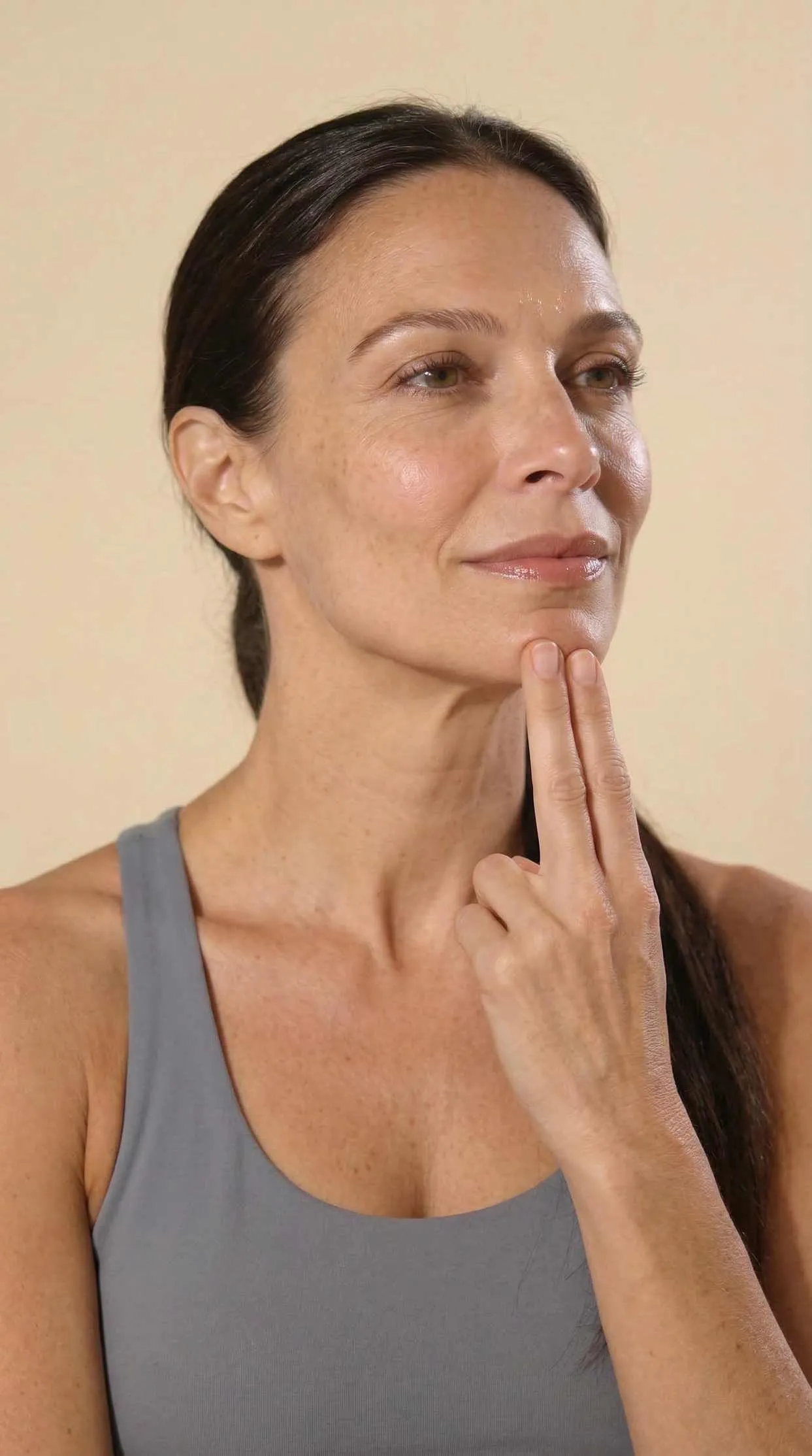 Woman resting her fingers along her jaw, cover of Gluvy's evening jaw relaxation routine